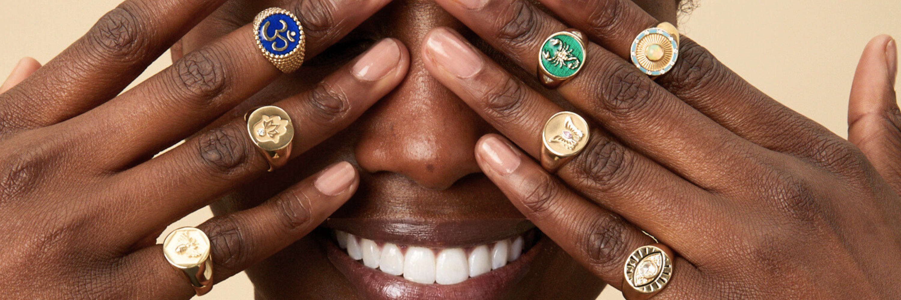 Rings collection image featuring a model wearing multiple gemstone rings styled in a clean, editorial setting