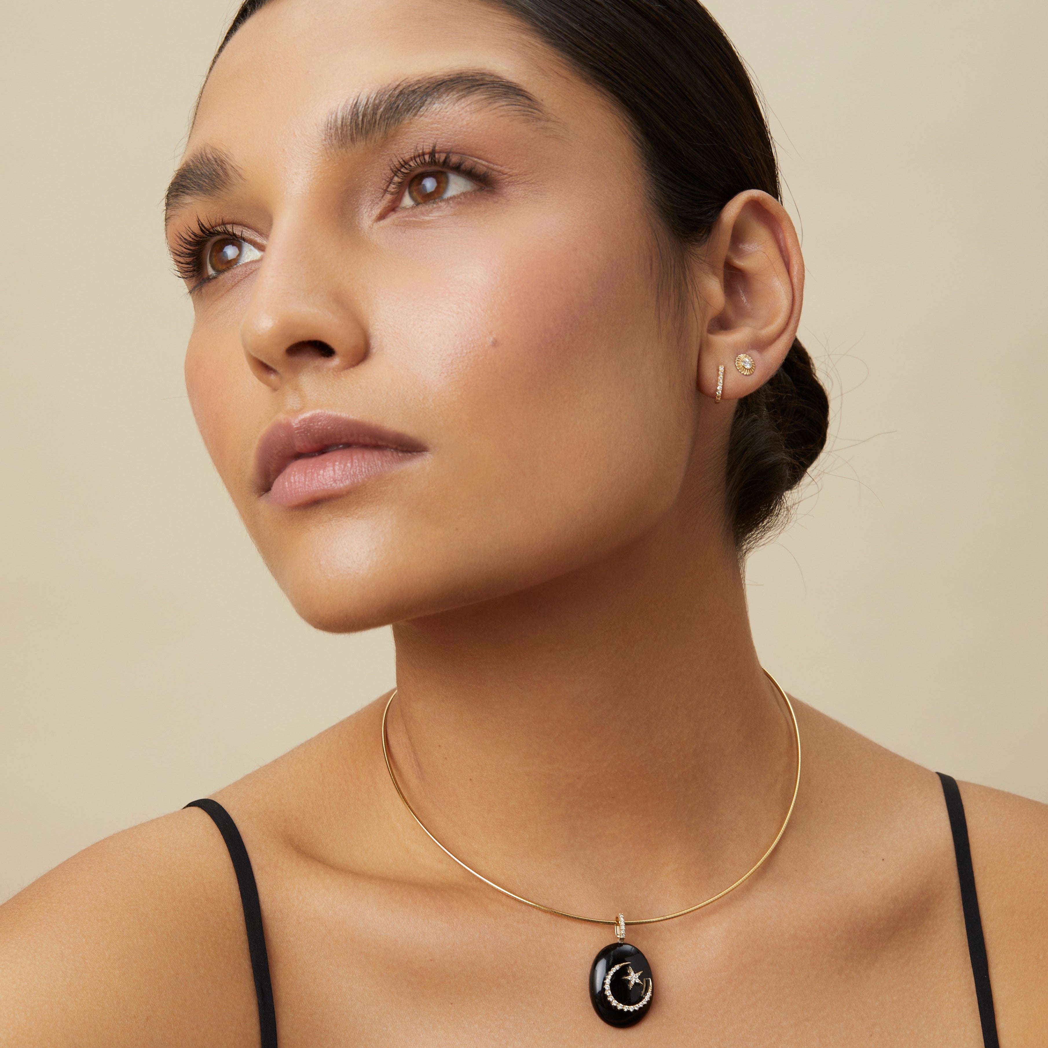 Model wearing black onyx moon-and-star pendant on simple chain
