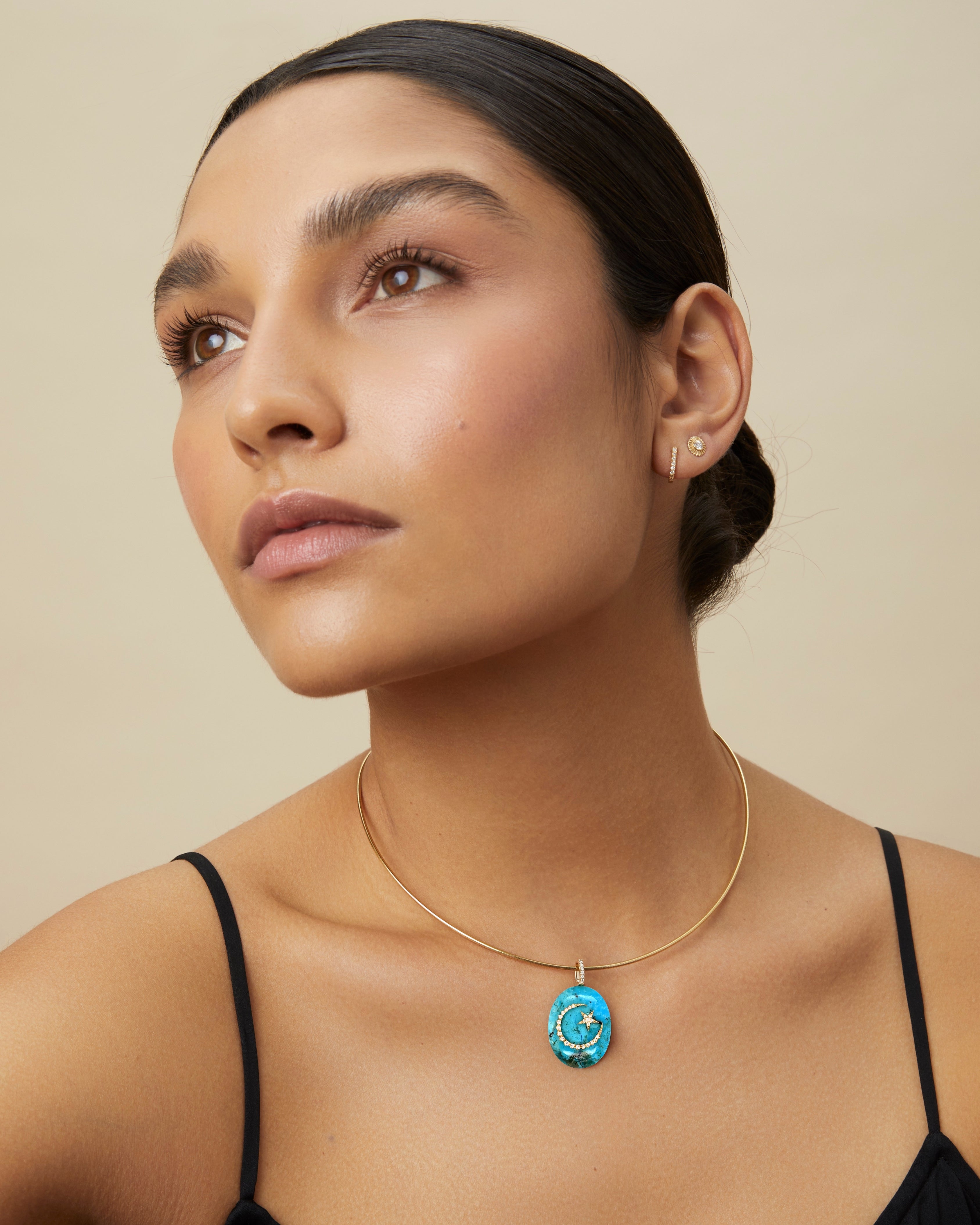 Model wearing large turquoise moon-and-star cabochon pendant