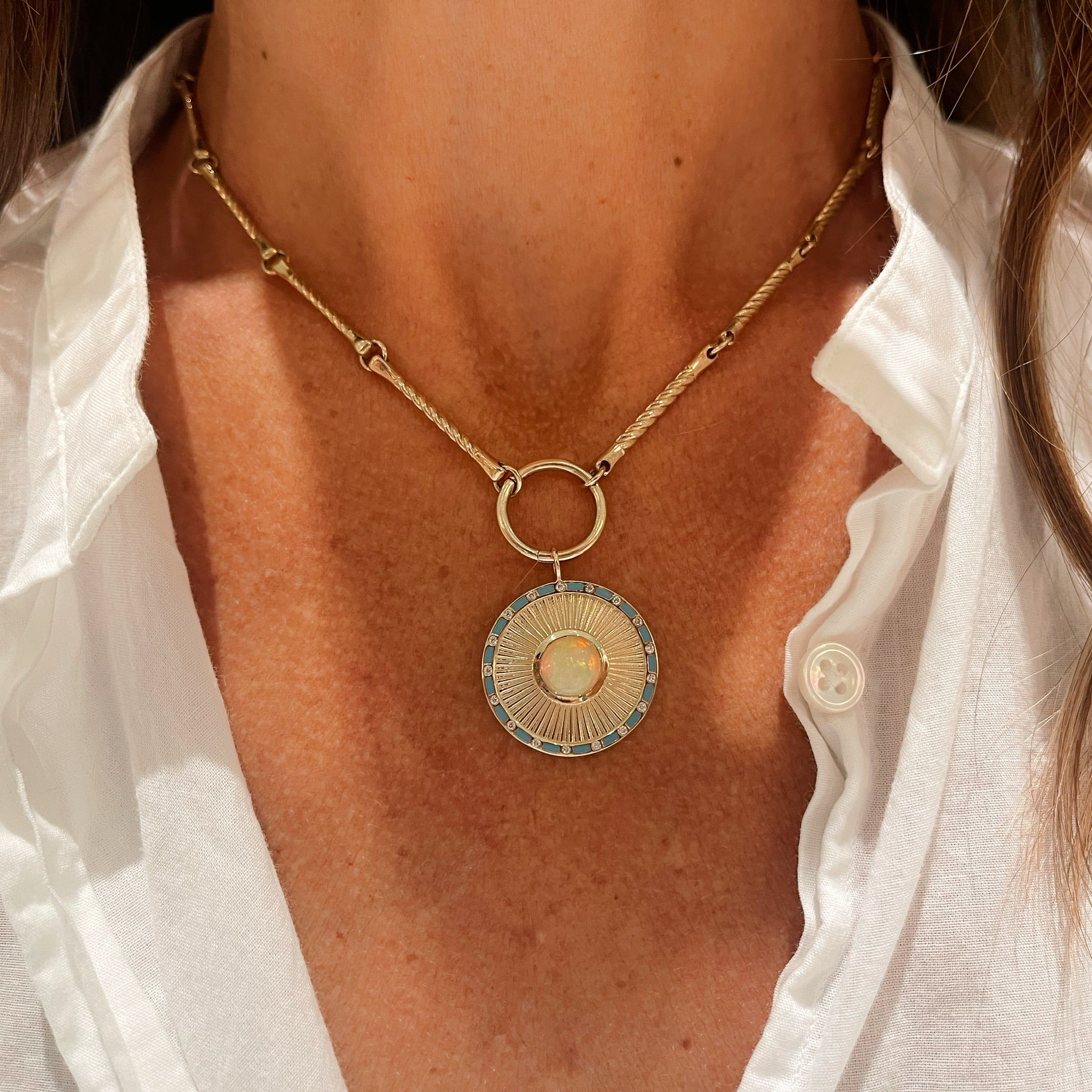 Close-up of model wearing the Clarity Pendant styled on a gold chain, showing scale and layering.