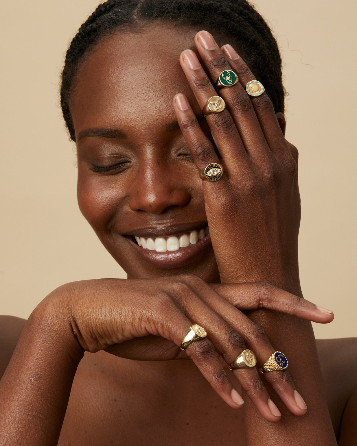 Model wearing layered gold rings including Evil Eye and Abundance Signet Ring from Kate Collins Jewelry