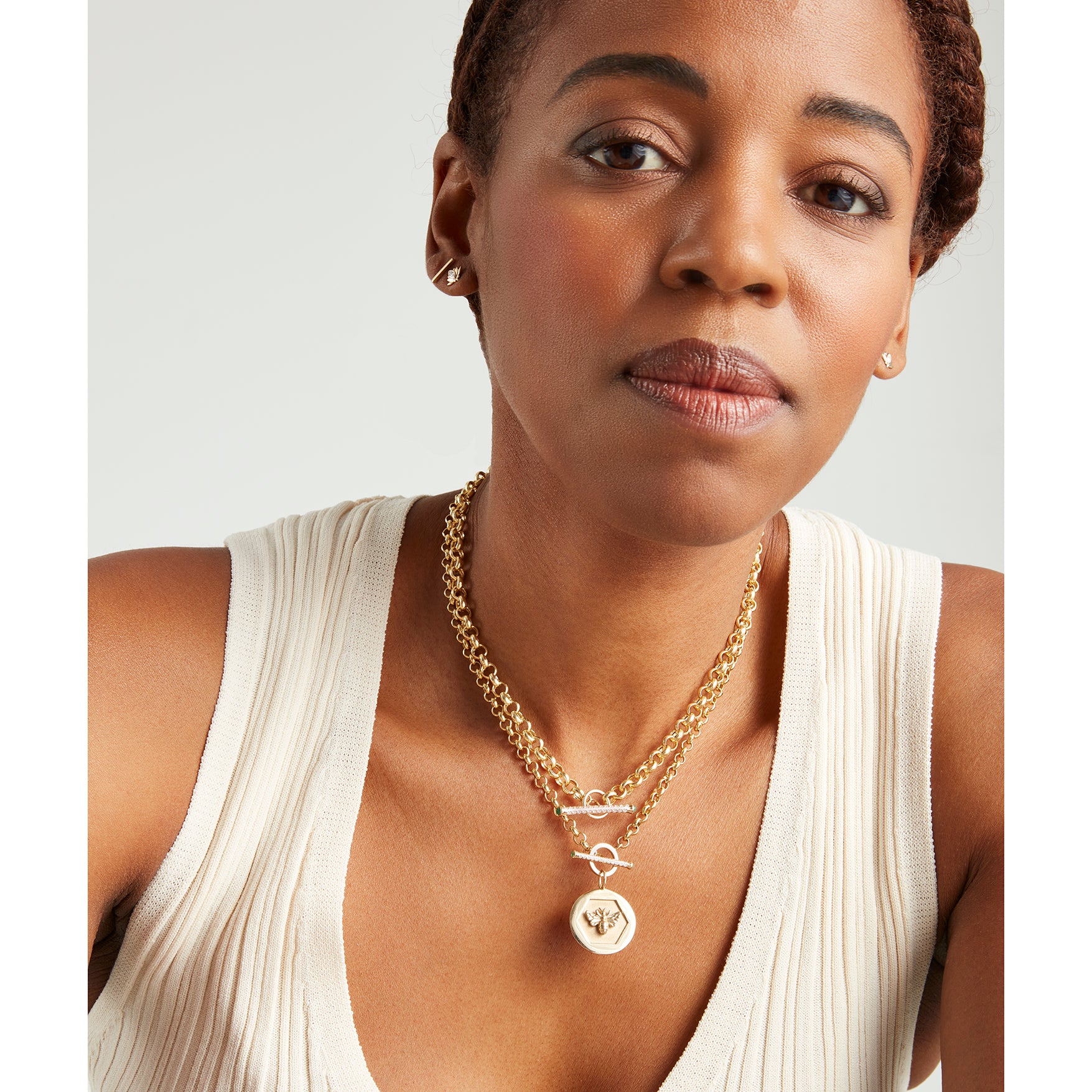 Model wearing layered Kate Collins necklaces including the 14k gold Abundance Pendant.