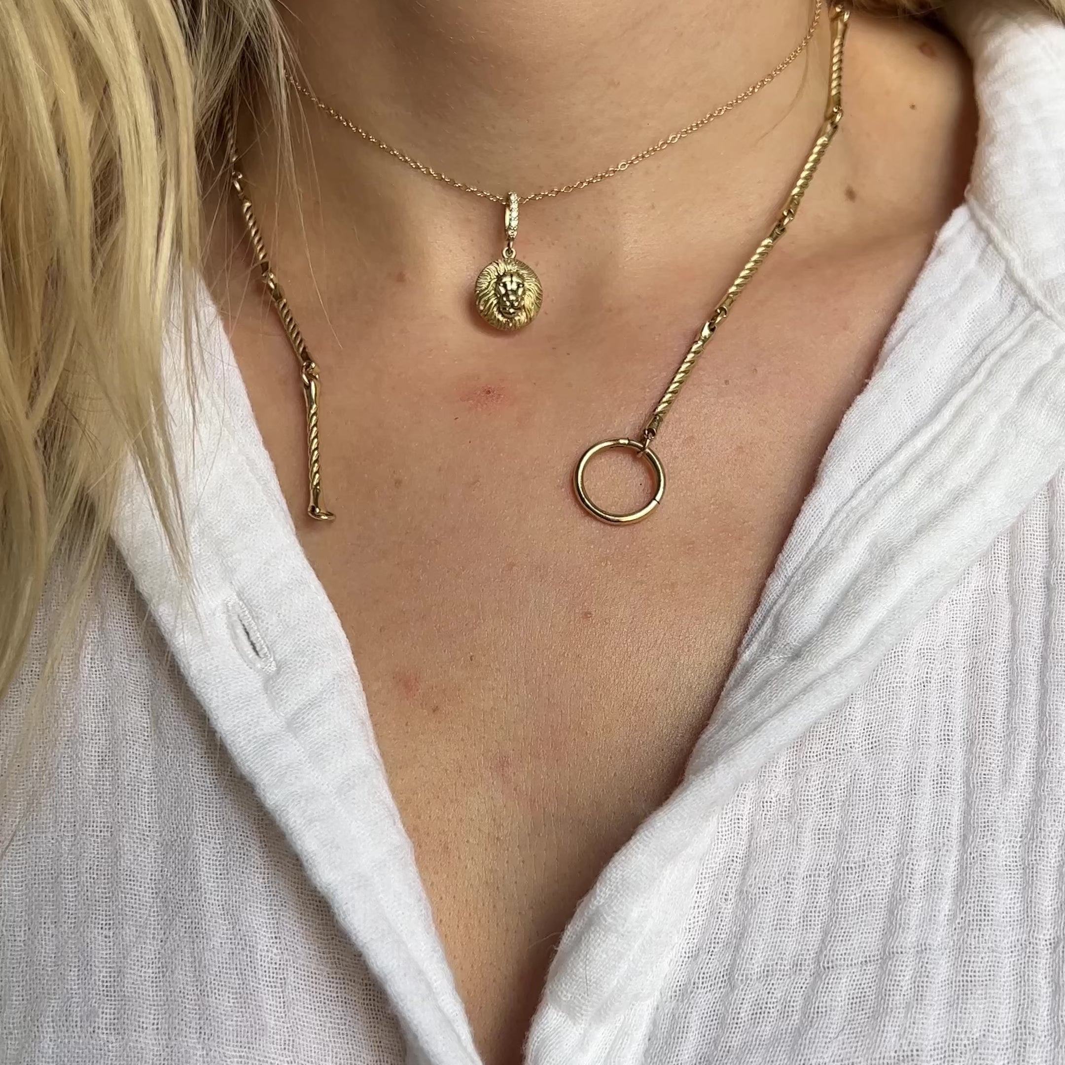 Close-up of layered gold necklaces featuring the Estrella Charm and coordinating pendants